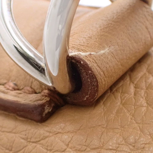 Kelly 28(内缝线)Taurillon Clemence 皮革,搭配钯金金属配件和 Tabac 驼色饰面。印有 □L 字样。